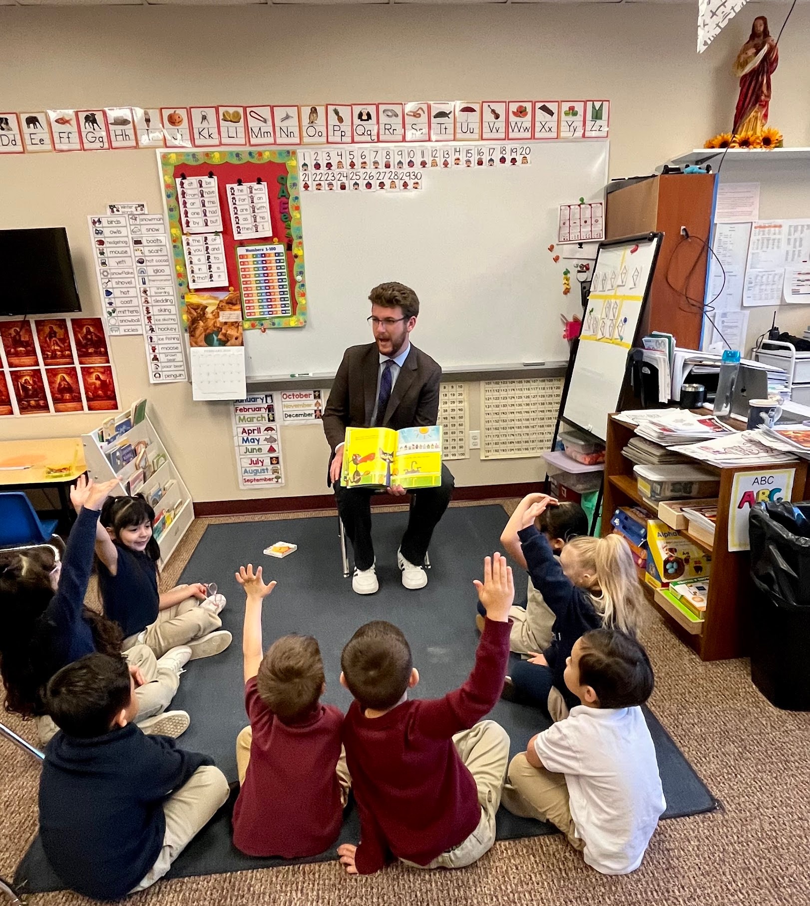 Pre-K students raising hands during a read-aloud session