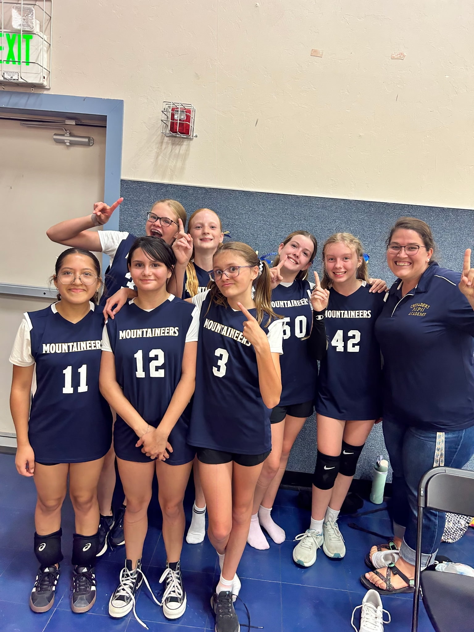 Mountaineers volleyball team posing together after a match at Pope John Paul II Academy