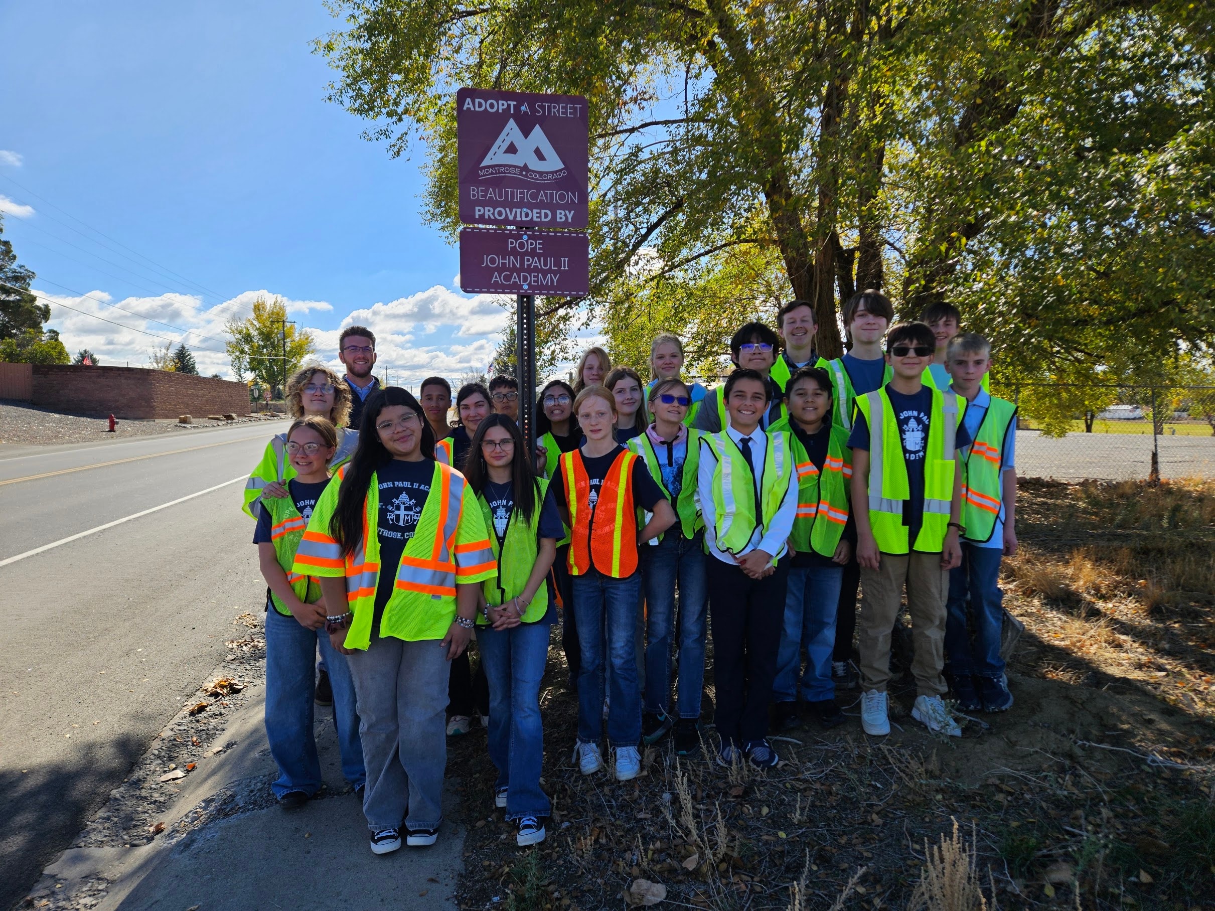 Pope John Paul II Academy students in safety vests at the Adopt-a-Street community service event in Montrose, Colorado